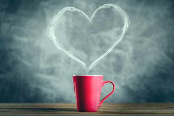 Cup of coffee with a heart shaped steam - Photo, Image