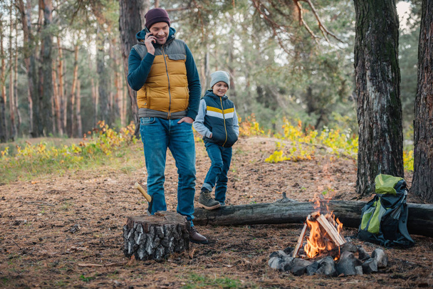 otec se smartphone a synem v lese - Fotografie, Obrázek