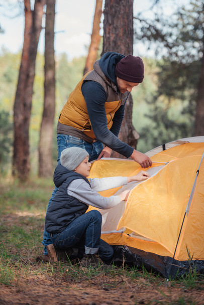 Pai e filho a montar tenda
 - Foto, Imagem