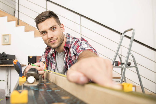 Man working on wood planks for home-improvement - Photo, Image