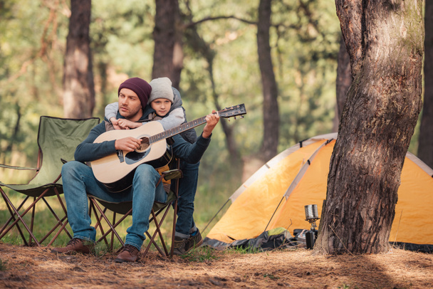 father and son with guitar in forest - Foto, Imagem