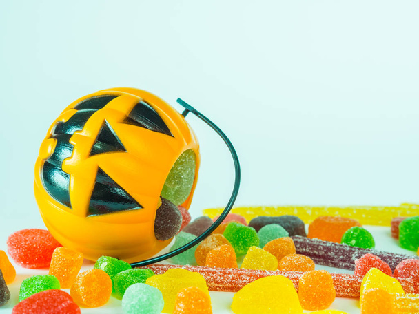Truco o tratar cubo de Halloween lleno de caramelos de colores sobre fondo blanco
 - Foto, imagen