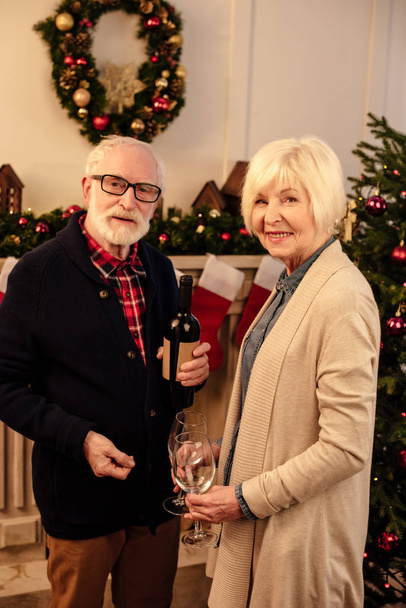 pareja de ancianos con vino en Navidad
 - Foto, Imagen