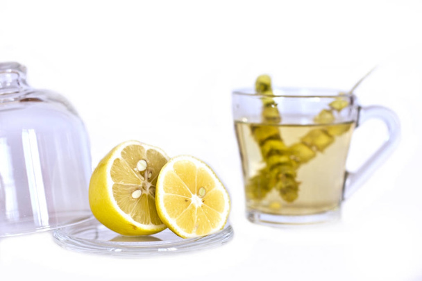 Hot tea with sage and lemon in a glass mug. - Фото, изображение