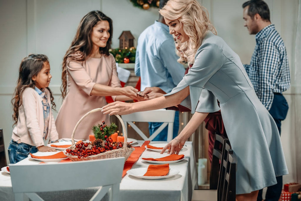 women decorating christmas table - Foto, afbeelding