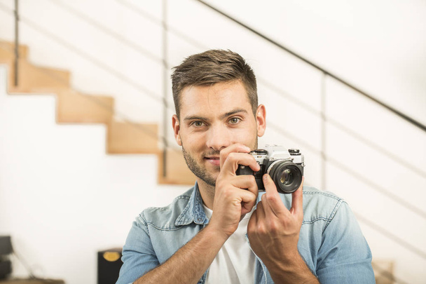 Man at home using vintage reflex camera - Zdjęcie, obraz