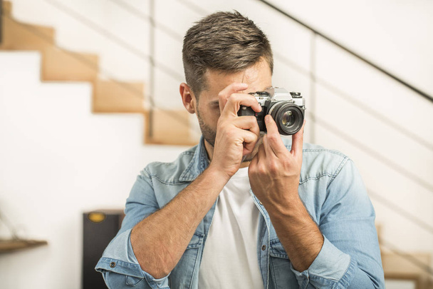 Man at home using vintage reflex camera - Zdjęcie, obraz