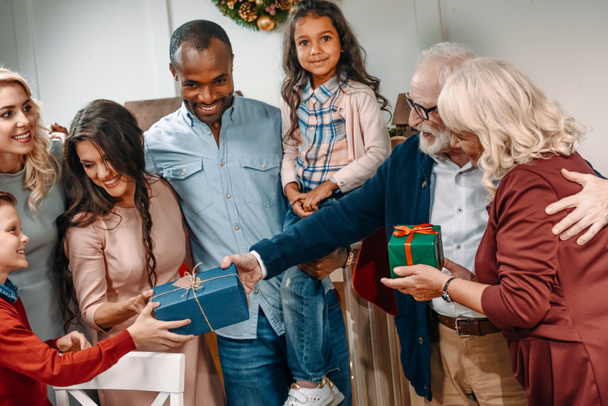 grandparents presenting christmas gifts to kids - Foto, imagen