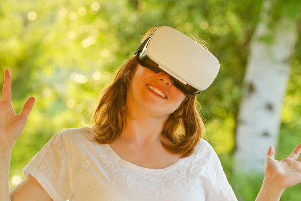 Tyttö virtuaalitodellisuuden kypärässä luonnon taustaa vasten. Sävytys
 - Valokuva, kuva