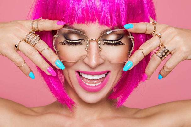 Красива модель в рожевій перуці і кольоровий макіяж з довгими кольоровими цвяхами
 - Фото, зображення