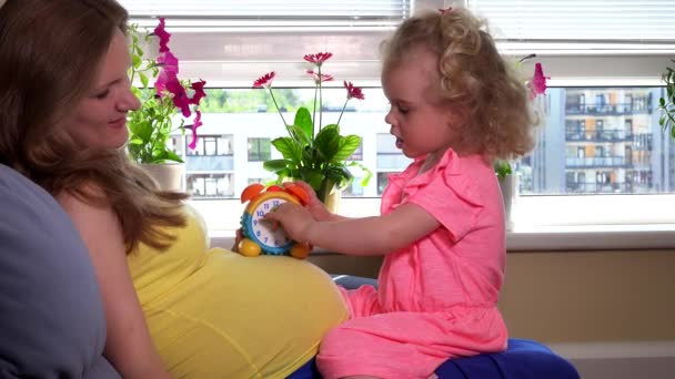 Έγκυος μητέρα διδασκαλία χαριτωμένο κοριτσάκι κόρη ρολόι ώρα αριθμούς - Πλάνα, βίντεο