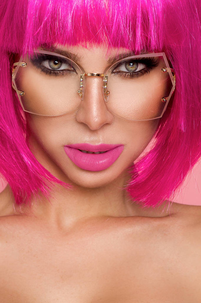 Hermosa modelo en peluca rosa y maquillaje de color con uñas de colores largos
 - Foto, Imagen