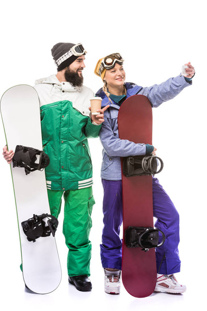 pareja con tablas de snowboard tomando selfie
 - Foto, imagen