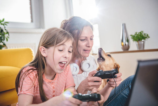 Anya és lánya játszik a videojátékkal, laptop otthon - Fotó, kép