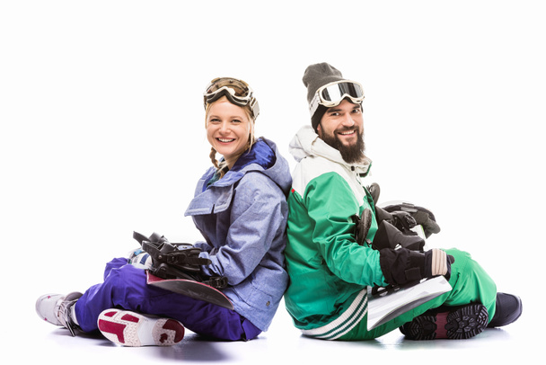paar in Snowboarden kostuums met snowboards - Foto, afbeelding