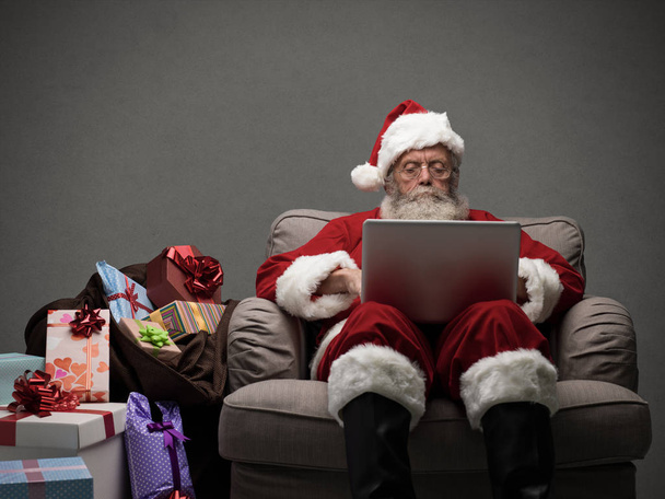 Santa Claus connecting with laptop - Photo, image