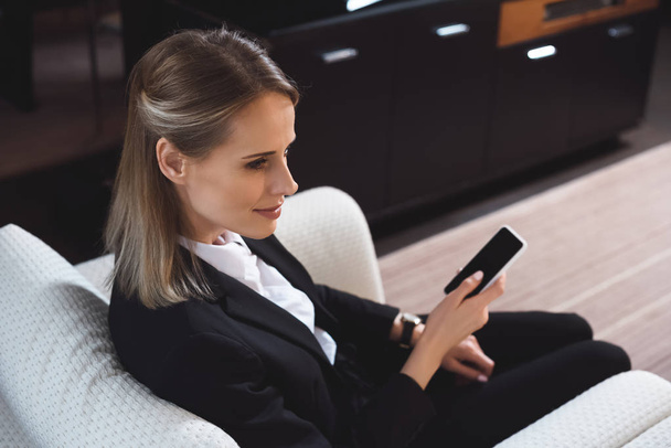 businesswoman with smartphone in hotel room - Фото, зображення