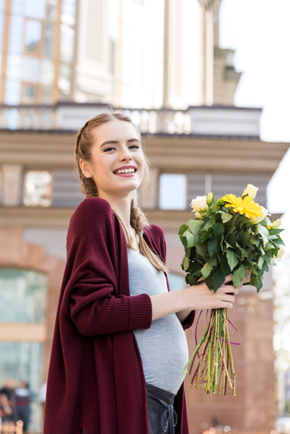 pregnant woman with bouquet of flowers - 写真・画像