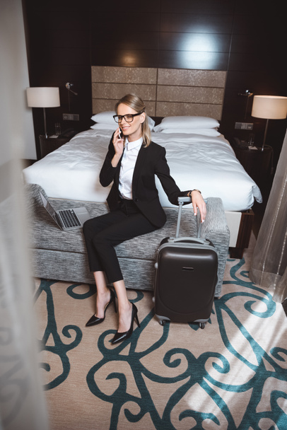 businesswoman using smartphone in hotel room - Fotó, kép