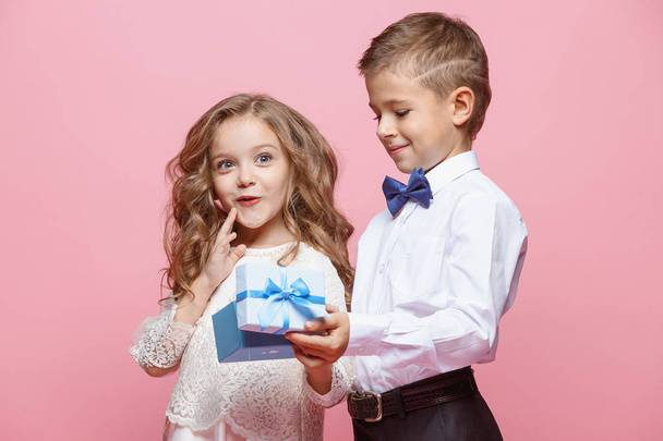 Boy and girl standing in studio on pink background - Photo, Image