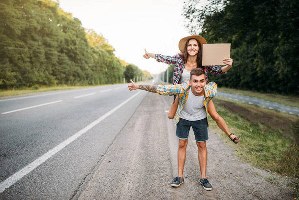hitchhiking couple with empty cardboard - Фото, зображення