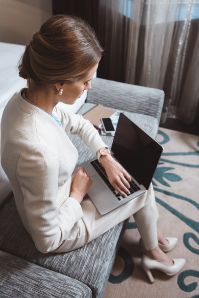 Femme d'affaires utilisant un ordinateur portable dans la chambre d'hôtel
 - Photo, image