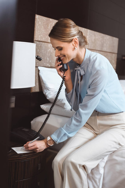 businesswoman talking by phone in hotel - Foto, afbeelding