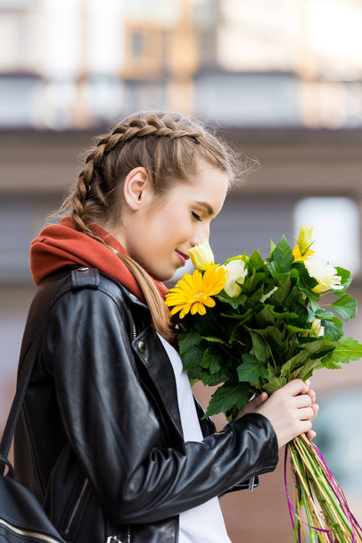 花の花束を持つ若い女性 - 写真・画像