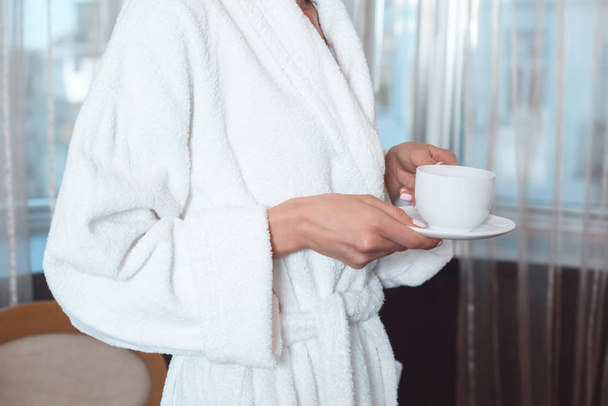 woman in bathrobe drinking coffee - Valokuva, kuva