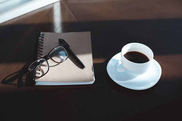 コーヒーのカップとノートブック - 写真・画像
