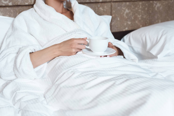 woman in bathrobe drinking coffee - Foto, imagen