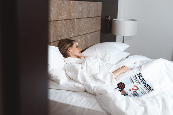 woman with magazine sleeping in bed  - Zdjęcie, obraz