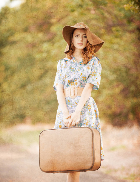 Mujer pelirroja con maleta de viaje
  - Foto, imagen