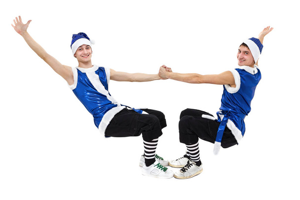 two Christmas men in blue santa clothes dancing against isolated white in full length. - Zdjęcie, obraz