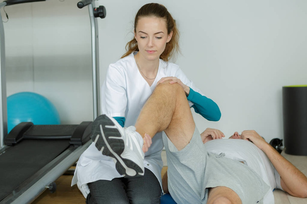 physiotherapist working on the leg of a man - Foto, Imagen