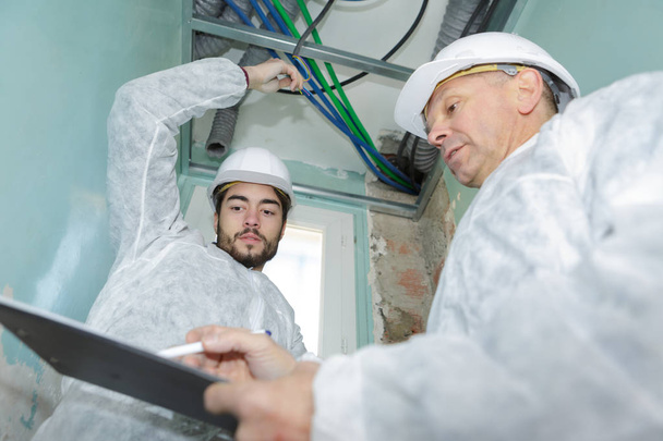 foreman showing the design to the electrician - Foto, Imagem