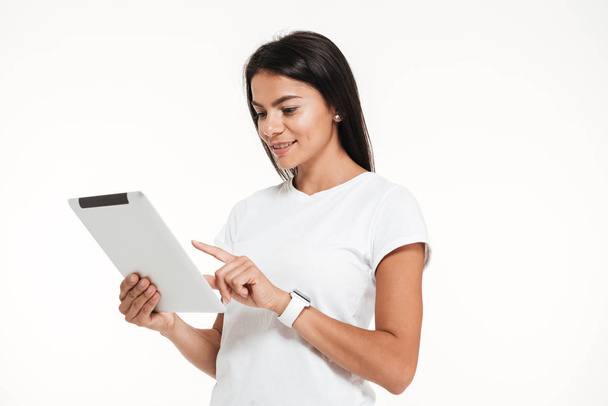 Retrato de uma mulher sorridente usando o computador tablet em pé
 - Foto, Imagem