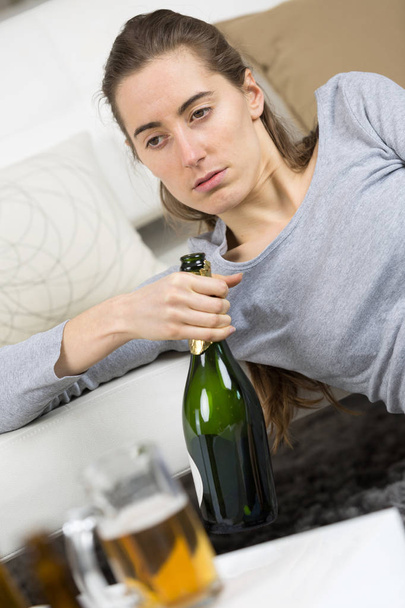 young drunken woman with bottle of wine - 写真・画像