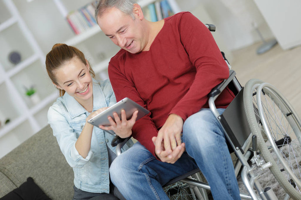 happy disabled man sitting in wheelchair with a nurse - Φωτογραφία, εικόνα