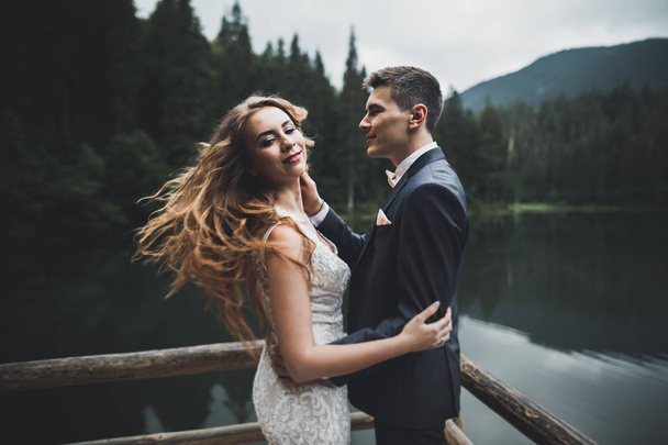 Perfect couple bride, groom posing and kissing in their wedding day - Zdjęcie, obraz