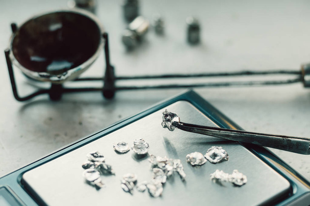 Jewelry tools. Jewellery. Goldsmith workplace, workspace on light background. Hand craft. Workshop. Manufacturing. Weigh-scales with granules of metal silver and platinum. Closeup. Toned - Photo, Image