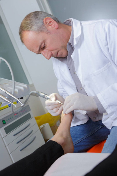 chiropodists removes dry skin of heel of the foot - Fotoğraf, Görsel