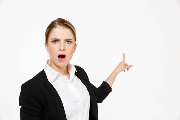 Shocked blonde business woman pointing back and looking at camera - Photo, image