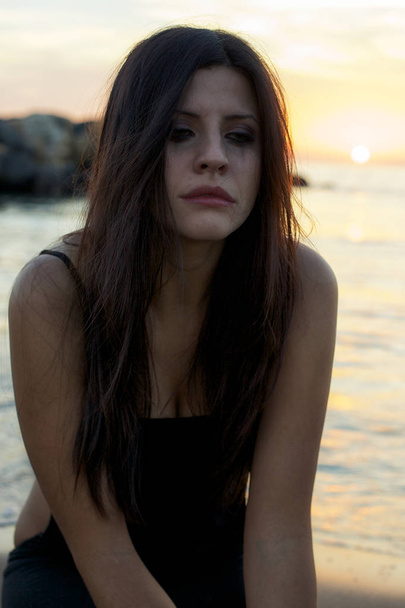 絶望的な日没海の前で泣いている女性 - 写真・画像