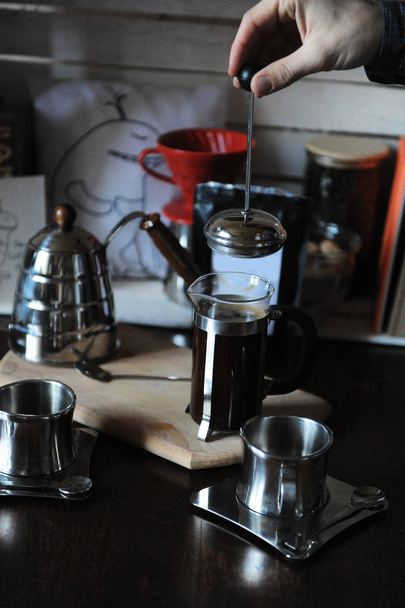 Proces přípravy kávy. Barista pokrývá francouzský tisk s víčkem. Balení s bílým štítkem - Fotografie, Obrázek