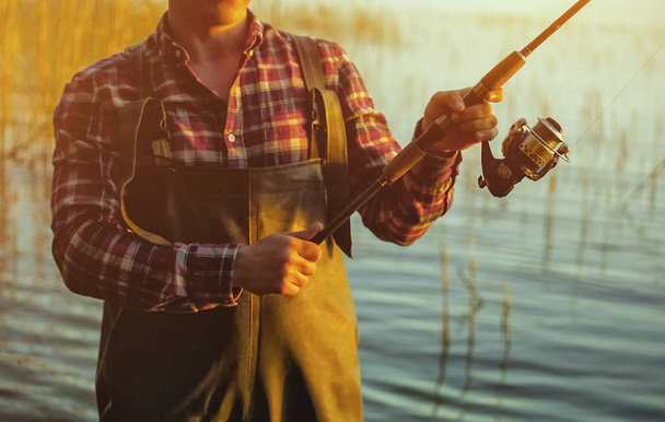  紡績用赤シャツの漁師は魚釣り - 写真・画像