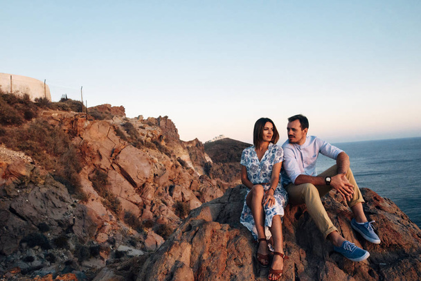 young happy couple at sunset hugging in rocky terrain - Photo, Image