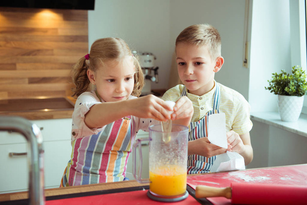 Portrait of two happy children which having fun during cooking c - Photo, Image
