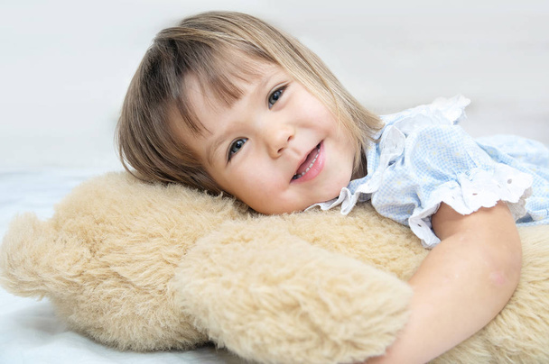 Little girl portrait happy smiling with Teddy bear hugging toy - Foto, afbeelding