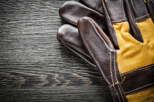 Leather safety gloves on wooden board - Φωτογραφία, εικόνα